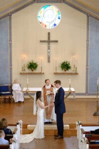 Wedding ceremony at St. Martin's in-the-Field Episcopal Church with bride and groom exchanging vows in front of altar.